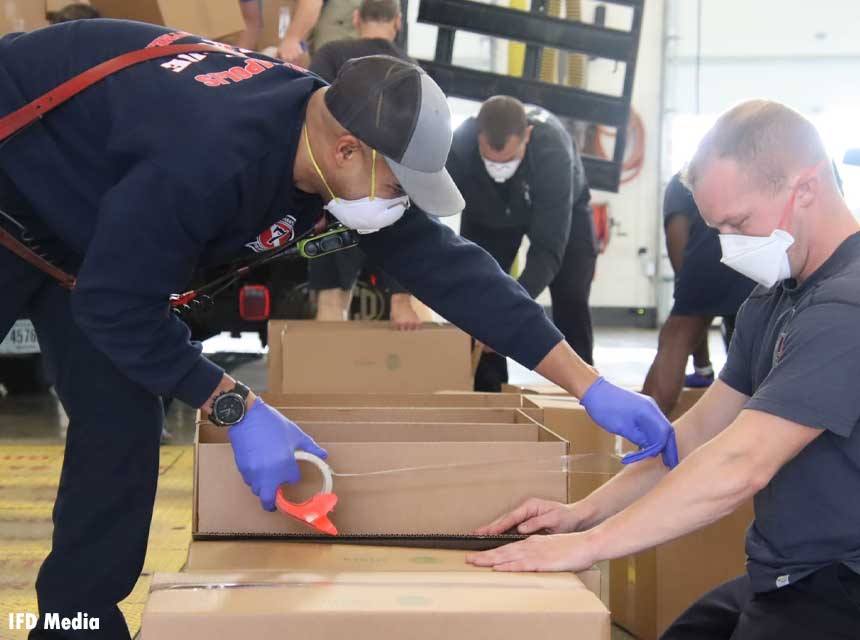 In December 2020, Indianapolis firefighters pack food boxes to be delivered to the local community