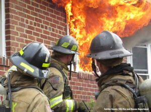 Fairfax County VA firefighters at a structure with fire blowing out the windows