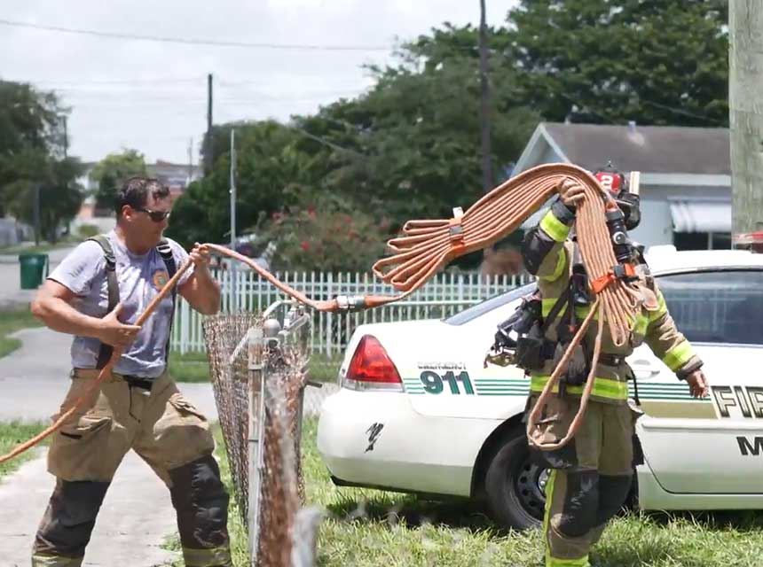 Miami-Dade FL firefighters stretch a hose load past obstacles