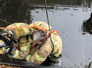 Firefighters on a rope going out a window