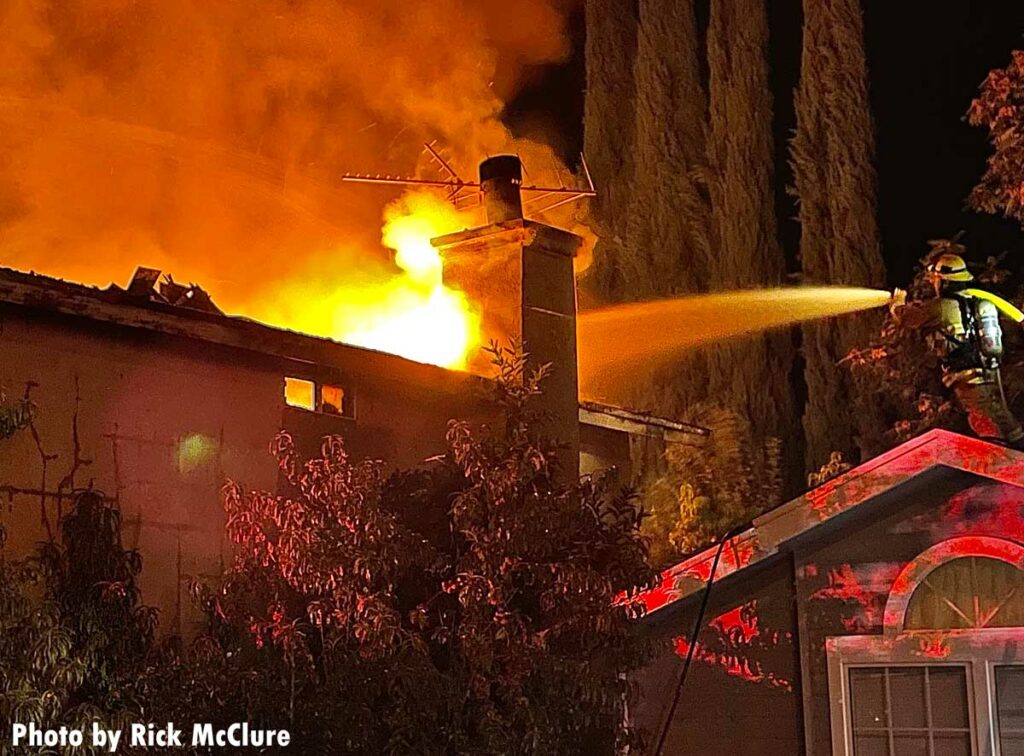 Firefighter on roof with a hose