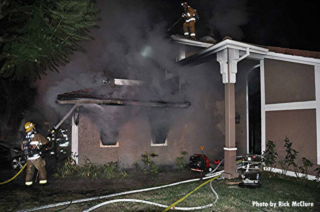 Firefighter with hoseline on exterior of building