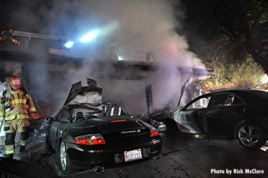 Smoke from a garage with two burned vehicles