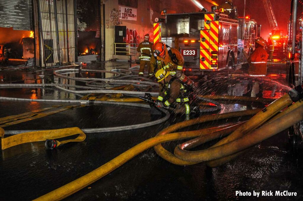 Firefighter sets up portable master stream amidst many hoselines