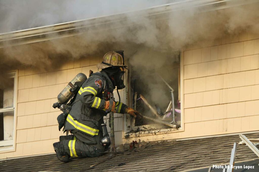 Firefighter on subroof clears window