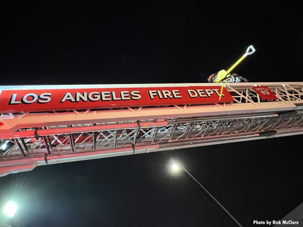 Firefighter moves along LAFD aerial ladder