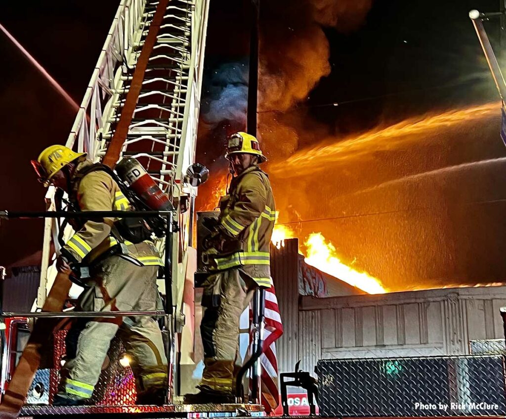 Flames behind LAFD firefighters on turntable