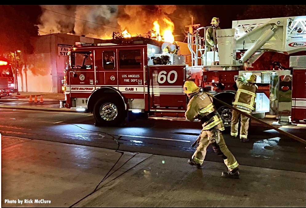 LAFD tower ladder bucket with firefighter pulling hose