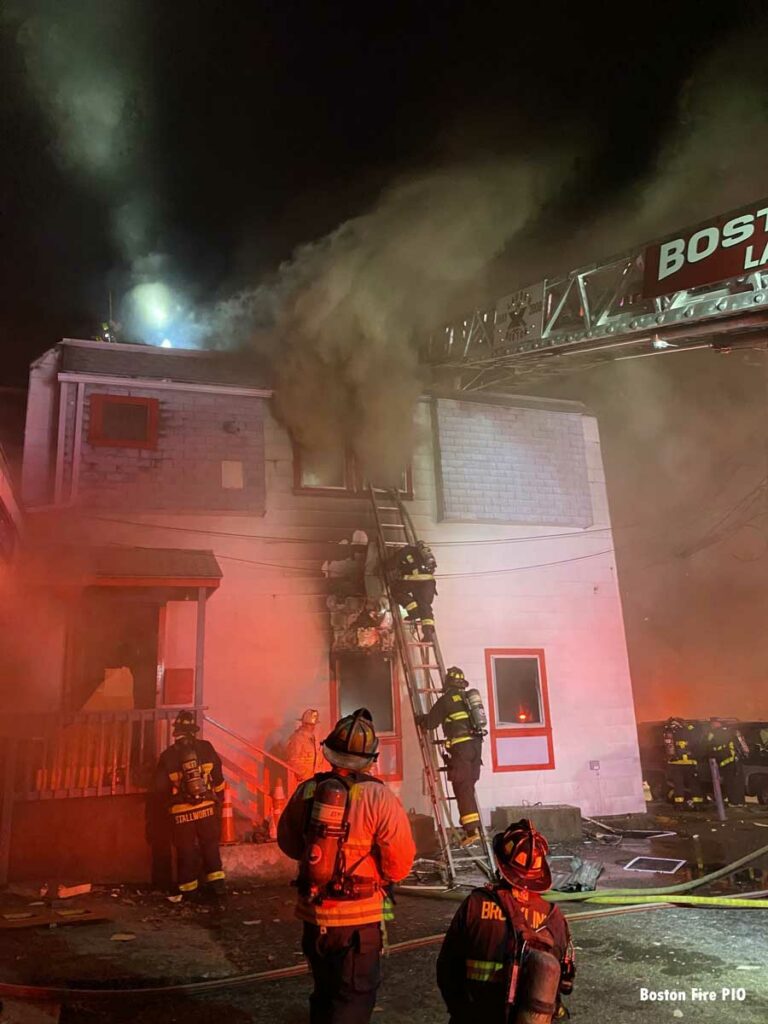 Firefighters scale a ladder at Boston fire