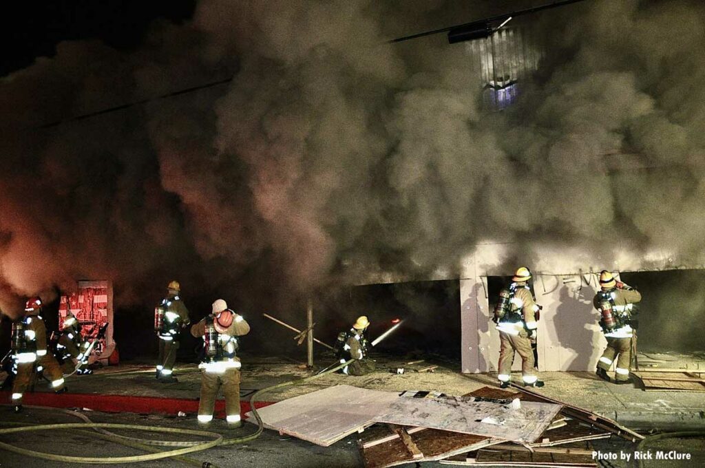 Firefighters cut through wall to attack fire