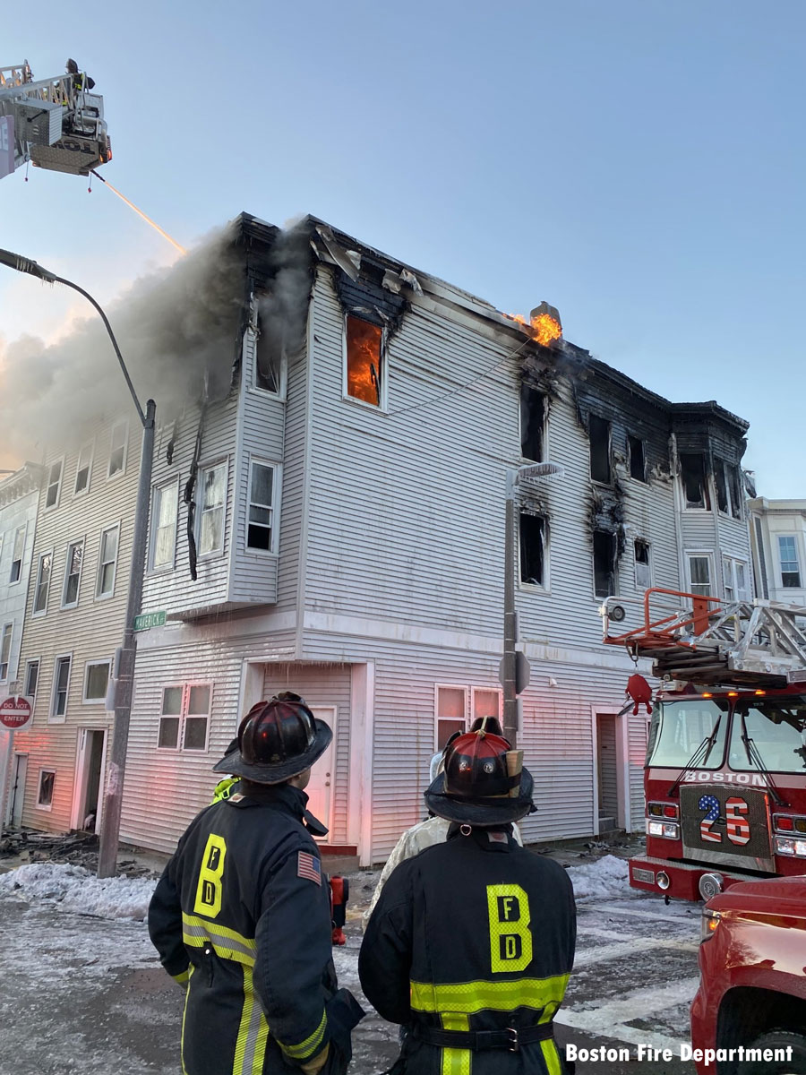 Tower ladder with master stream and Boston firefighters at six-alarm fire