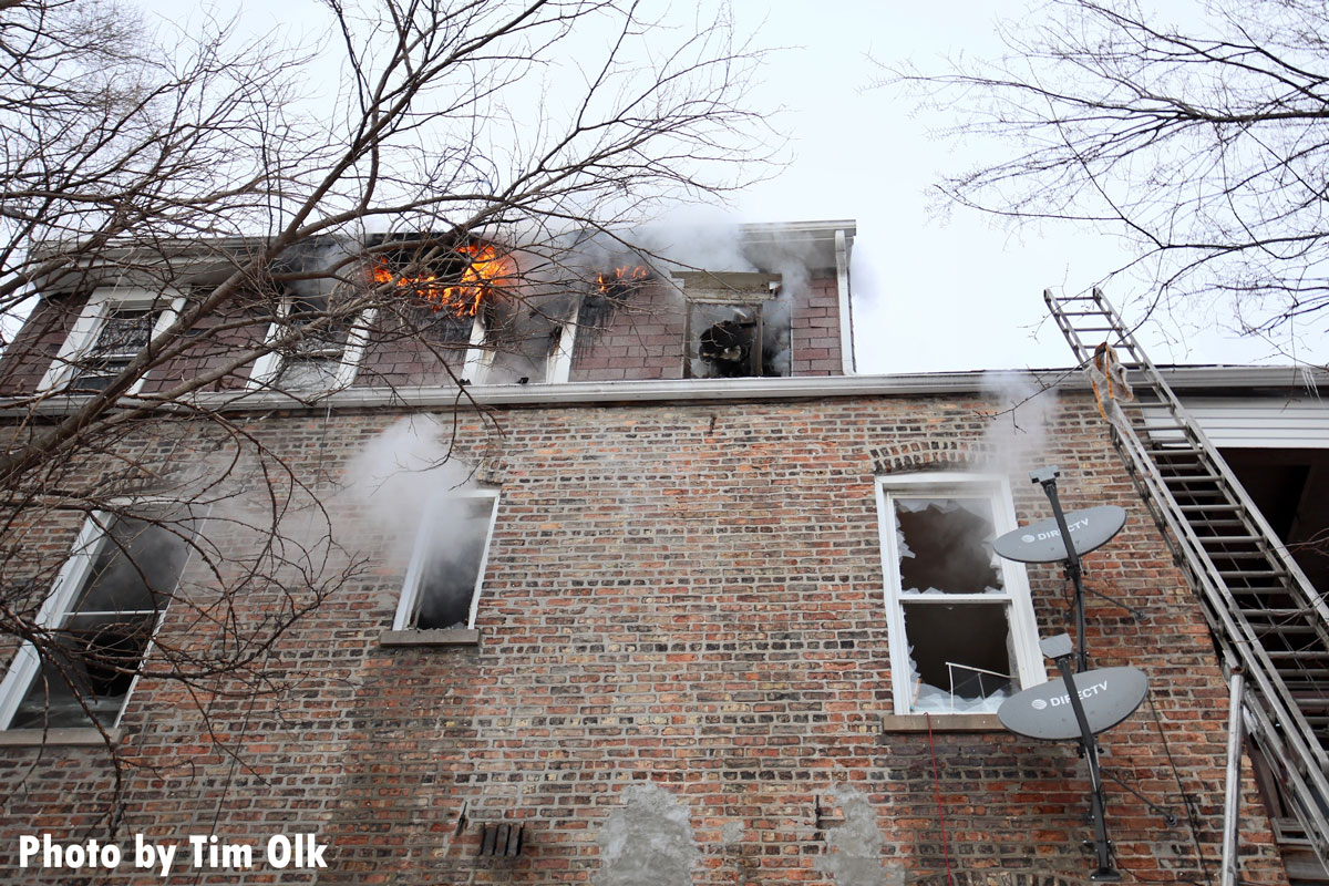 Fire and a ladder coming from upper floor of home