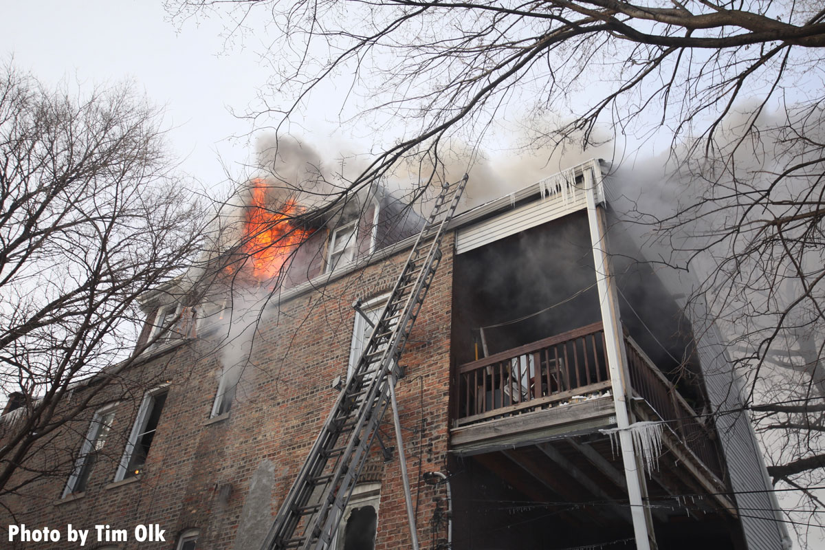 Flames shoot from an upper floor of a home with a Bangor ladder