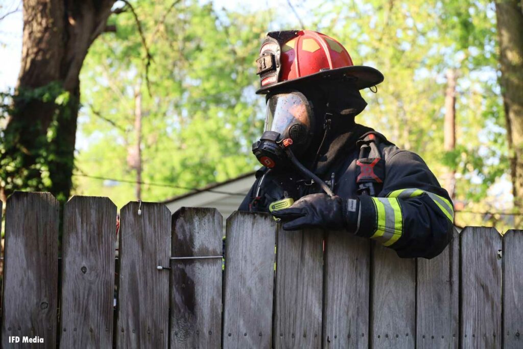 Indianapolis firefighter in full gear on fence