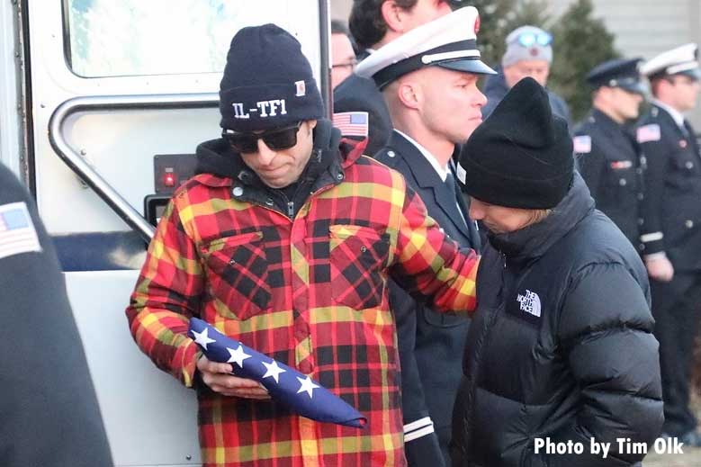 Handler holds flag after passing of firehouse dog