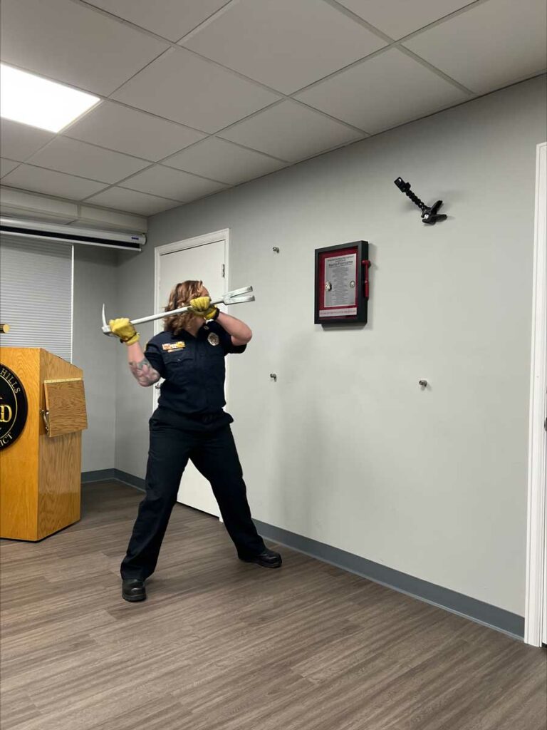 Female firefighter with halligan poised to strike