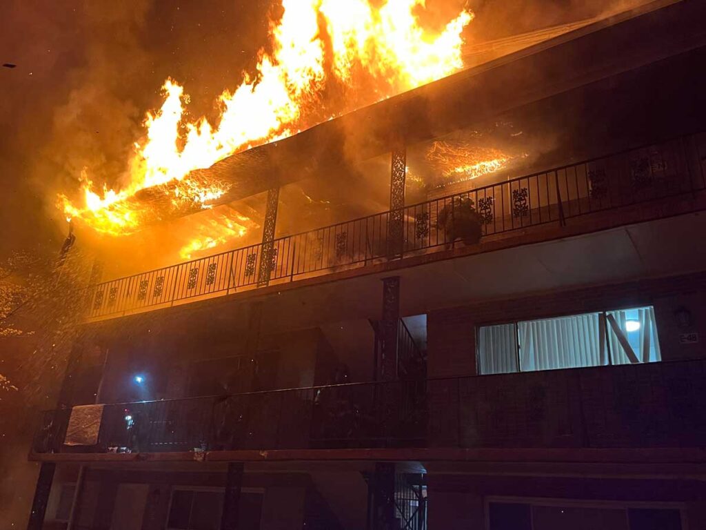 Firefighter ona balcony facing major fire