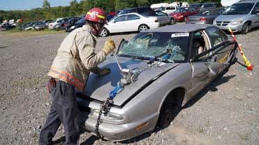 Firefighter uses tools at vehicle extrication training