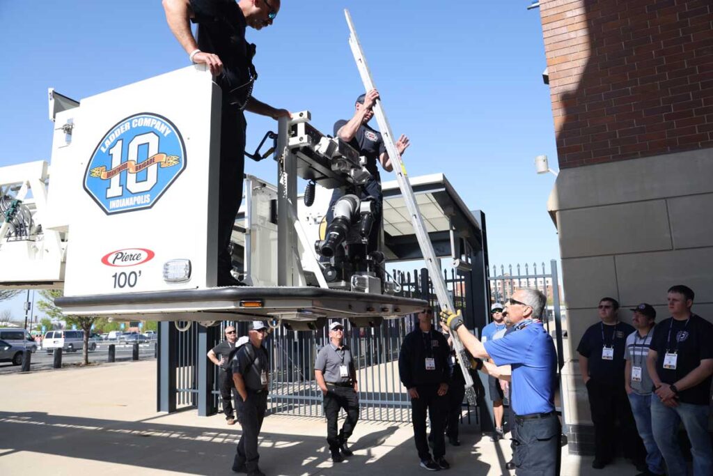 Ladder being handed up to firefighters in tower ladder bucket