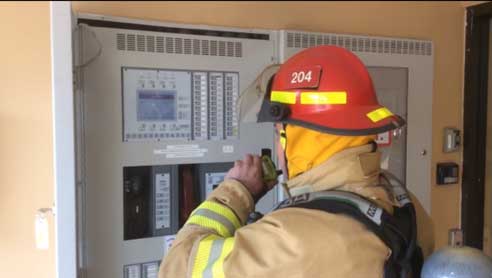 Firefighter and radio report from control panel