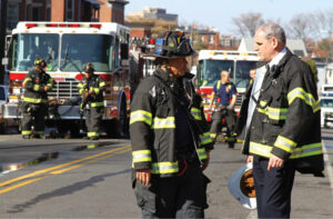 Firefighters talking in front of a fire truck