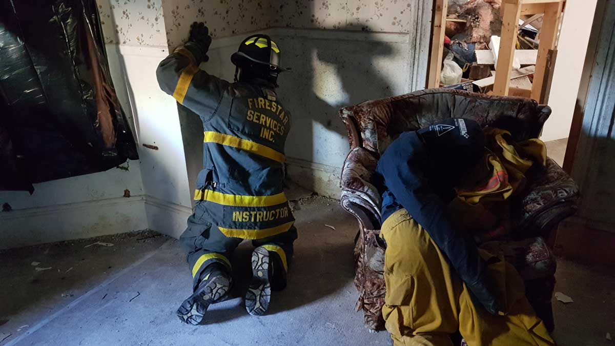 Firefighter searching along a wall