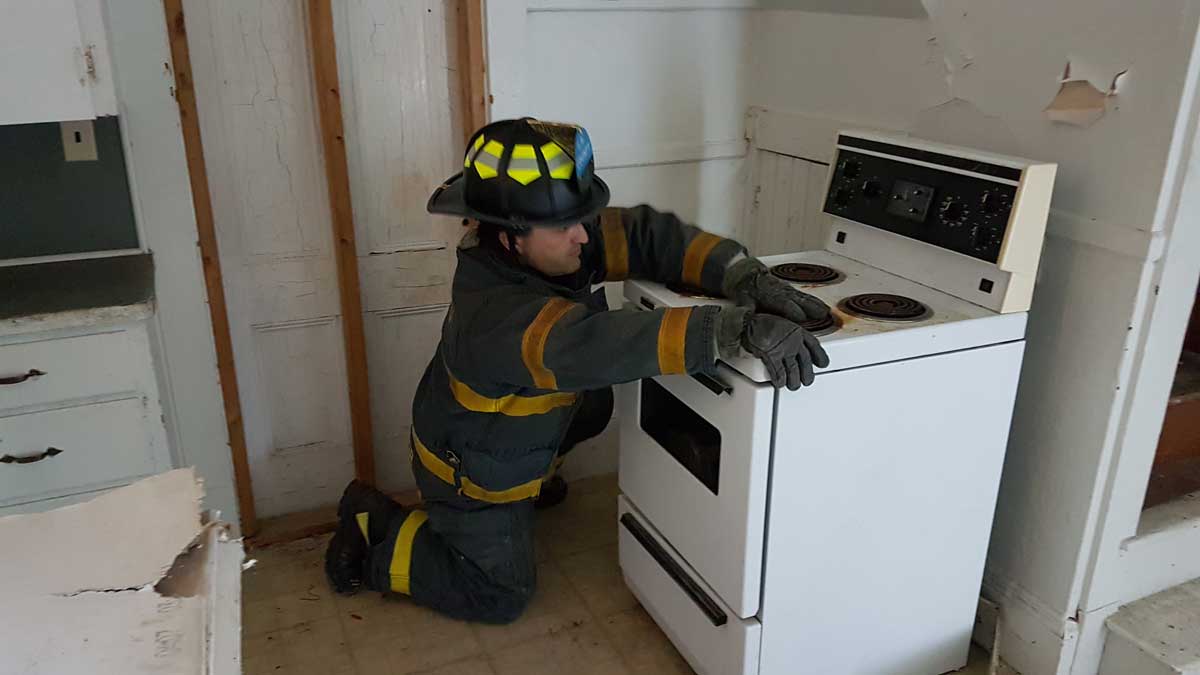 Firefighter searching on top of a stove