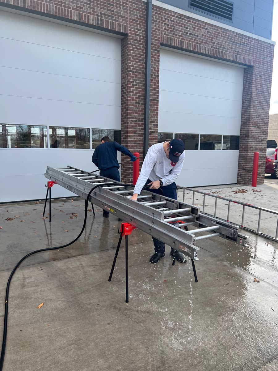 Firefighters working on ladders outside station