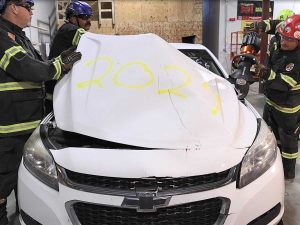 Firefighters remove hood from electric vehicle