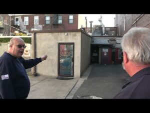 Glenn Corbett points to some buildings